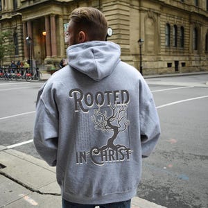 May include: Grey hooded sweatshirt with a black tree graphic and the text "Rooted in Christ" on the back.