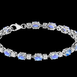 Puede incluir: Un brazalete de plata con piedras azules ovaladas y peque&ntilde;as piedras transparentes. El brazalete tiene un cierre de broche.