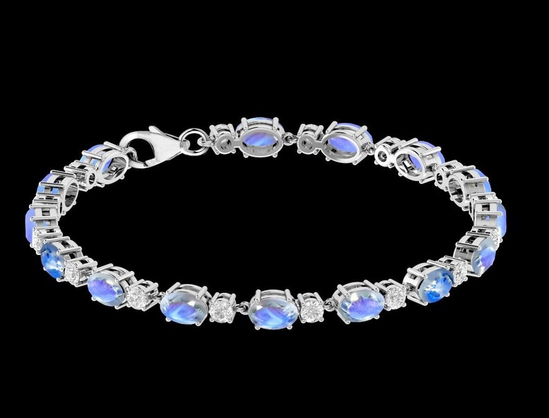 Puede incluir: Un brazalete de plata con piedras azules ovaladas y peque&ntilde;as piedras transparentes. El brazalete tiene un cierre de broche.