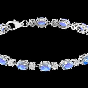 Puede incluir: Un brazalete de plata con piedras azules ovaladas y peque&ntilde;os diamantes transparentes engastados en el metal.