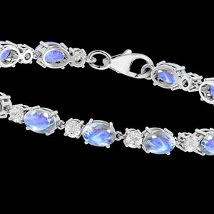 Puede incluir: Un brazalete de plata con piedras azules ovaladas y piedras transparentes redondas m&aacute;s peque&ntilde;as.