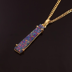 May include: A gold chain necklace with a pendant featuring a long, rectangular, iridescent black opal stone.