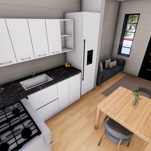 Puede incluir: Vista interior de una cocina y comedor modernos. Los armarios y electrodom&eacute;sticos blancos contrastan con una encimera negra. Una mesa y sillas de madera est&aacute;n en primer plano, con un sof&aacute; peque&ntilde;o y una ventana en el fondo.