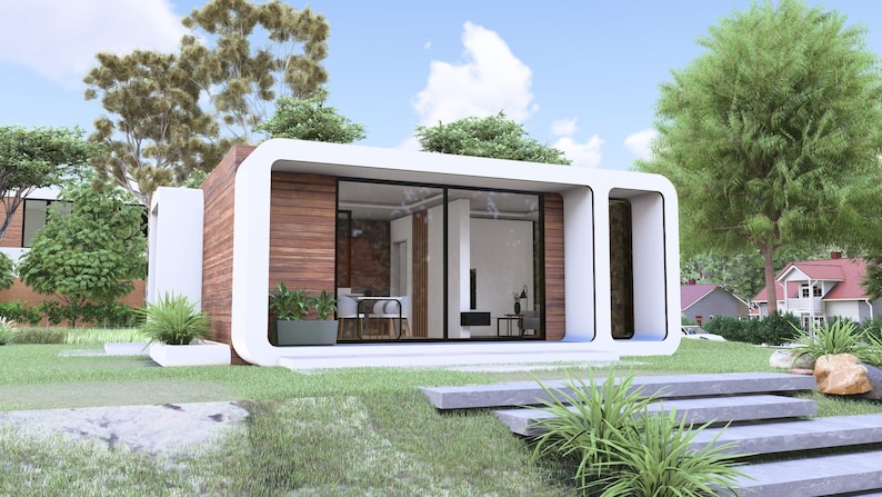 Peut inclure: Maison moderne et minimaliste avec un ext&eacute;rieur blanc et des panneaux de bois. De grandes fen&ecirc;tres en verre offrent une vue sur l'int&eacute;rieur. La maison est entour&eacute;e d'herbe verte, d'arbres et d'un ciel bleu.