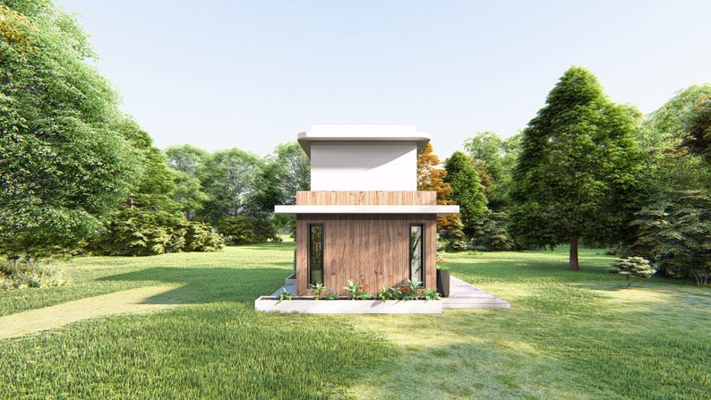 Op de afbeelding: Een moderne, twee verdiepingen tellende hut met een lichtgekleurde bovenverdieping en een houten benedenverdieping. De hut heeft twee ramen en is omgeven door weelderig groen gras en bomen. De lucht is helder en blauw.