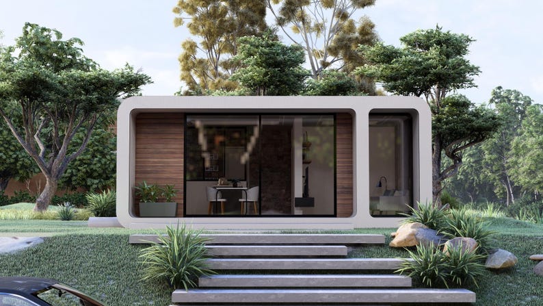 Peut inclure: Une petite maison rectangulaire blanche et moderne avec de grandes fen&ecirc;tres en verre et un mur d'accent en bois. La maison est entour&eacute;e d'une verdure luxuriante, notamment des arbres, de l'herbe et des buissons. Des marches en b&eacute;ton m&egrave;nent &agrave; l'entr&eacute;e.