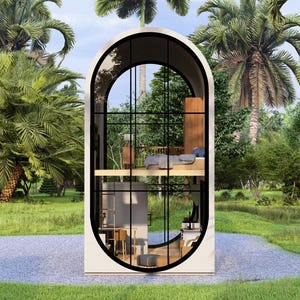 May include: A modern, two-story tiny home with an arched window design. The interior features a bedroom and living space, visible through the large glass windows. The home is surrounded by lush green grass and palm trees, creating a tropical setting.