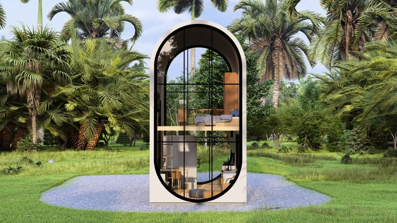 May include: A modern, two-story tiny home with an arched window design. The interior features a bedroom and living space, visible through the large glass windows. The home is surrounded by lush green grass and palm trees, creating a tropical setting.
