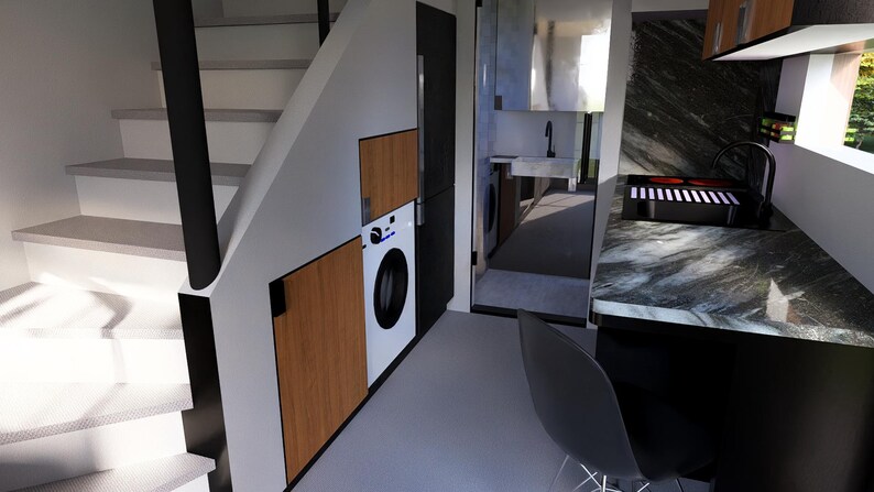 以下が含まれることがあります： モダンでミニマリストな家の内観。階段、洗濯機、大理石のカウンタートップを備えたキッチンエリアがあります。デザインは木と黒のアクセントを取り入れています。