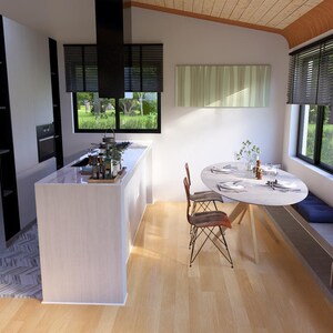 Puede incluir: Interior de cocina moderno con una isla blanca, nevera de acero inoxidable y zona de comedor con mesa redonda y sillas. La habitaci&oacute;n cuenta con grandes ventanales con persianas y suelo de madera.