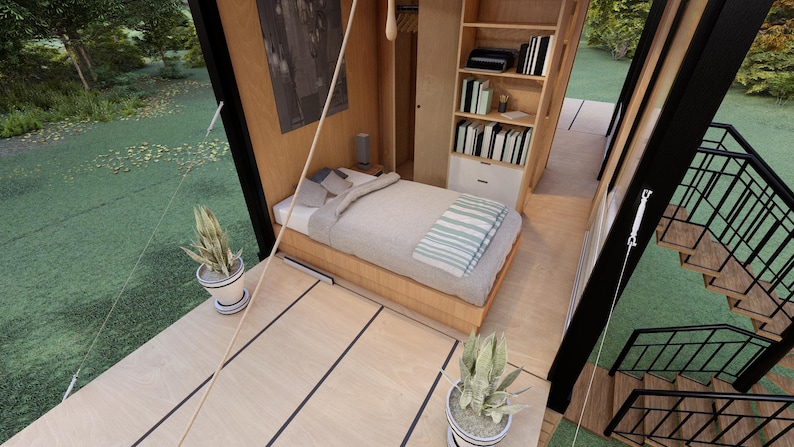 Pu&ograve; includere: Vista interna di una piccola cabina moderna con letto, libreria e scale. Il letto ha una trapunta di colore chiaro e una coperta a righe. Una piccola pianta in vaso si trova sul ponte di legno. La cabina &egrave; circondata dal verde.