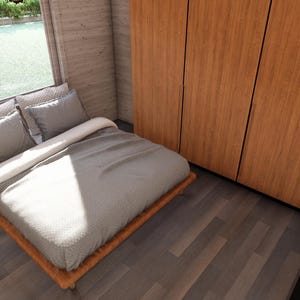 Puede incluir: Interior de dormitorio con cama, almohadas y armario de madera. La cama tiene una colcha gris y almohadas. Una peque&ntilde;a mesita de noche de madera con cajones est&aacute; al lado de la cama. Una ventana ofrece vistas al exterior.