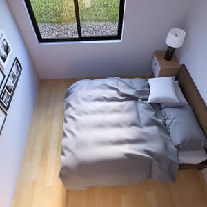 Puede incluir: Una escena de dormitorio con una cama con ropa de cama gris, una almohada blanca y una cabecera de madera. Una peque&ntilde;a mesita de noche con una l&aacute;mpara est&aacute; al lado de la cama. Una colecci&oacute;n de cuadros enmarcados cuelga de la pared. Se ve una ventana.