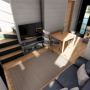 Puede incluir: Vista interior de una casa peque&ntilde;a moderna. La sala de estar cuenta con una alfombra gris, un sof&aacute; azul, una mesa de madera con dos sillas y un televisor en una estanter&iacute;a gris. Una escalera conduce a un nivel superior.