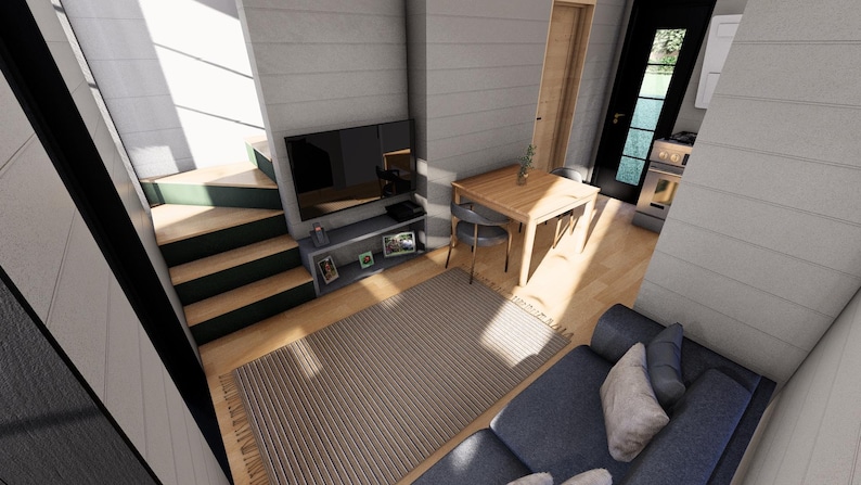 Puede incluir: Vista interior de una casa peque&ntilde;a moderna. La sala de estar cuenta con una alfombra gris, un sof&aacute; azul, una mesa de madera con dos sillas y un televisor en una estanter&iacute;a gris. Una escalera conduce a un nivel superior.