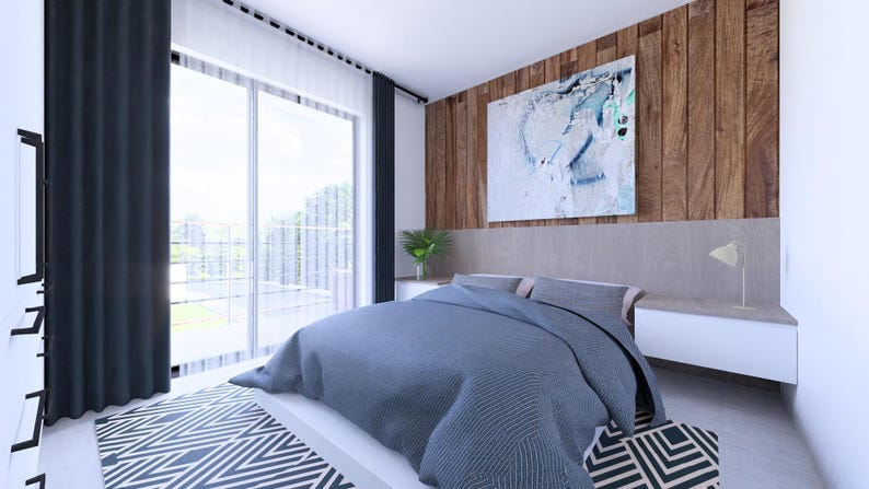 May include: A modern bedroom with a large bed covered in a blue comforter. The room features a wooden accent wall, a large window with dark curtains, and a geometric patterned rug. A piece of abstract art hangs above the bed.