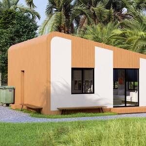Puede incluir: Una caba&ntilde;a moderna de una sola planta con un exterior marr&oacute;n claro y paneles blancos. La caba&ntilde;a tiene ventanas grandes, un peque&ntilde;o banco y un cubo de basura verde. Est&aacute; rodeada de exuberante hierba verde y follaje tropical.