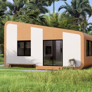 Puede incluir: Una caba&ntilde;a moderna y minimalista con exterior de madera clara y detalles blancos. La estructura presenta grandes ventanas, una puerta corredera de cristal y un peque&ntilde;o banco. La caba&ntilde;a est&aacute; situada en una zona verde.