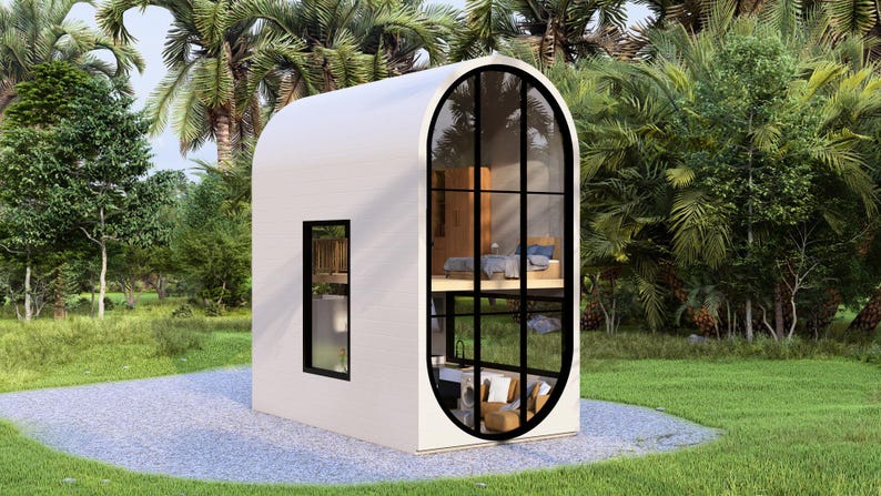 May include: A modern, white, two-story tiny house with a rounded roof and large, arched windows. The windows have black frames. The house is surrounded by lush greenery and palm trees, with a gravel path leading up to it.