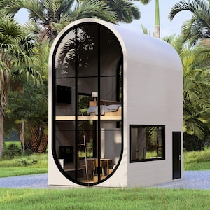 May include: A modern, two-story white structure with a curved roof and large, arched windows. The windows offer a view of the interior, including a bedroom and living space. The building is surrounded by lush green grass and palm trees.