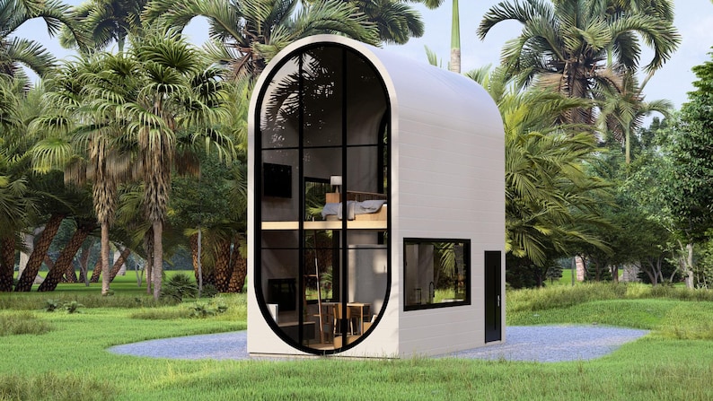 May include: A modern, two-story white structure with a curved roof and large, arched windows. The windows offer a view of the interior, including a bedroom and living space. The building is surrounded by lush green grass and palm trees.
