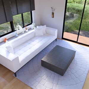 Puede incluir: Un sal&oacute;n moderno con un sof&aacute; blanco, una mesa de centro gris y una alfombra gris claro. Grandes ventanas con persianas oscuras ofrecen vistas al exterior. Estanter&iacute;as y objetos decorativos completan el ambiente.