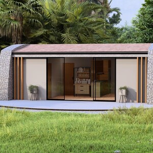 May include: A modern, single-story home with a stone facade and a flat roof. The home has large sliding glass doors and is surrounded by lush greenery. The interior features a kitchen and living area.