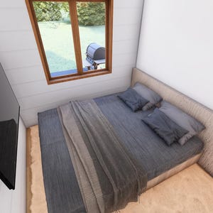 May include: A bedroom with a bed, pillows, and a blanket. A large black television is mounted on the wall. A window with a view of the outdoors is visible.