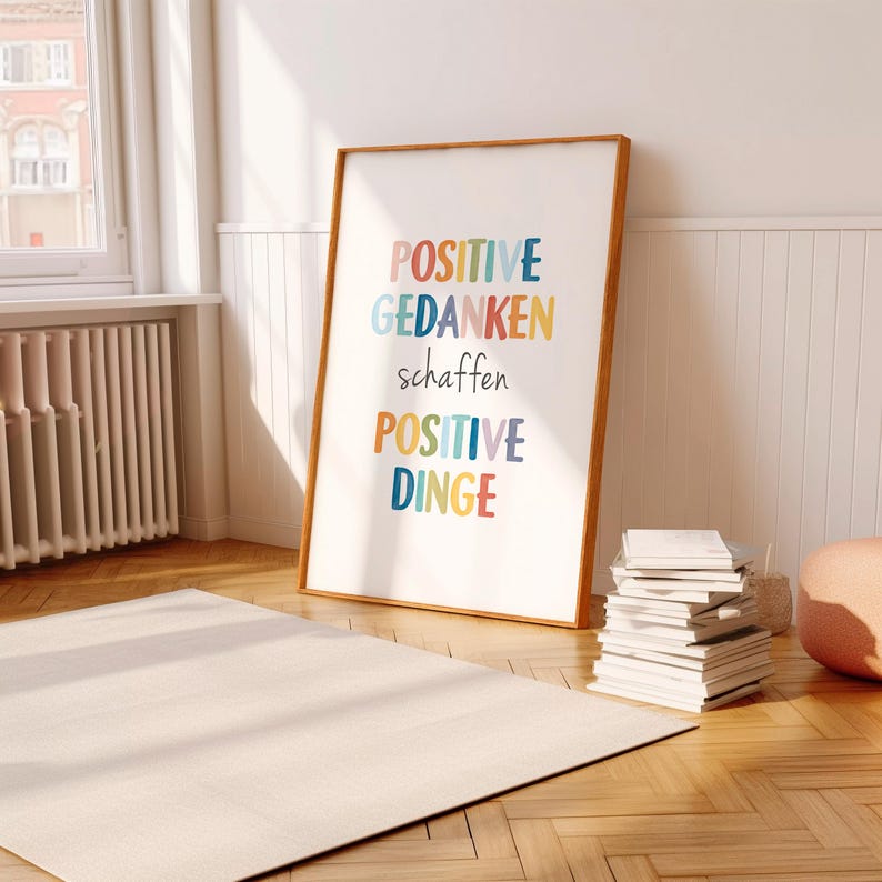 Peut inclure: Une impression encadr&eacute;e avec le texte "POSITIVE GEDANKEN schaffen POSITIVE DINGE" en lettres color&eacute;es sur un fond blanc.