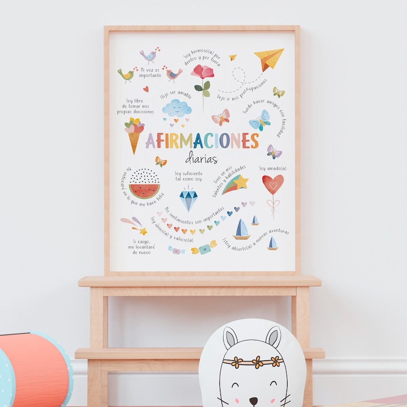 May include: A framed print with the words "AFIRMACIONES diarias" in a colorful, illustrated design. The artwork features various icons, including birds, butterflies, a watermelon slice, and a paper airplane, with inspirational phrases in Spanish.