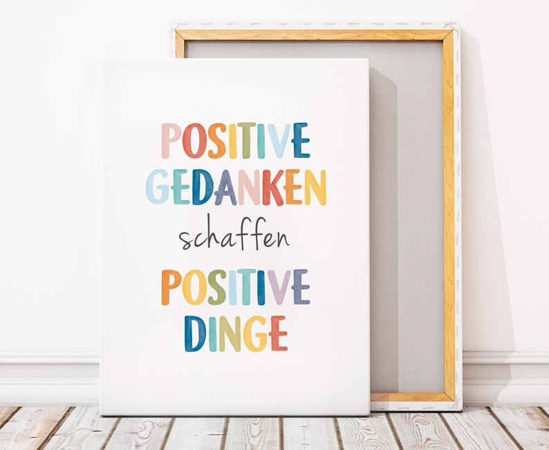Peut inclure: Une impression sur toile blanche avec le texte "POSITIVE GEDANKEN schaffen POSITIVE DINGE" en lettres color&eacute;es. Le texte est en allemand et se traduit par "Les pens&eacute;es positives cr&eacute;ent des choses positives."