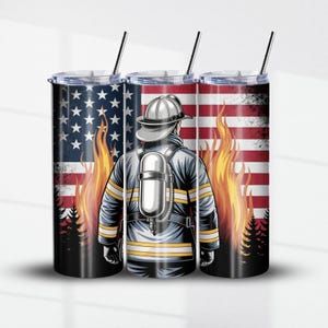 Puede incluir: Tres vasos aislados de acero inoxidable con pajitas negras. Cada vaso presenta un diseño de bombero frente a una bandera estadounidense y llamas. El bombero lleva un casco y un tanque de oxígeno.