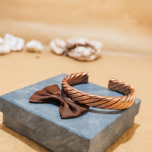 Copper bracelet shown on a small packaging box