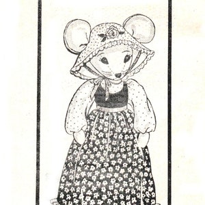 May include: Black and white line drawing of a mouse wearing a dress and a bonnet. The mouse is standing in a frame with the text "DESIGN 504" below it.
