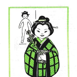 以下が含まれることがあります： 黒と緑の着物姿の日本人形。花柄の伝統的な着物。人形は緑の枝に花を持っている。人形は黒い髪飾りをつけており、黒いヘッドバンドをしている。人形は白い背景の前に立っている。DESIGN 7244.