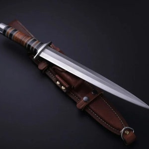 May include: A silver dagger with a brown leather handle and a brown leather sheath. The dagger has a long, sharp blade and a pointed tip.