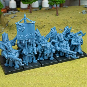 May include: A collection of blue miniature fantasy figures, possibly dwarves, on a black base. They are equipped with weapons and some carry a banner. The figures are on a green surface, suggesting a tabletop game setting.