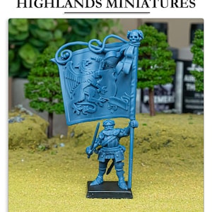 Puede incluir: Figura en miniatura azul de un soldado sosteniendo una bandera con un emblema de grifo. La figura está sobre una base negra, con una espada. La bandera tiene una parte superior decorativa. El texto "HIGHLANDS MINIATURES" está en la parte superior.