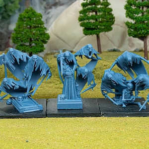 May include: Three blue miniature fantasy figures. One figure is a standing grim reaper with a sword. The other two figures are ghosts with skulls and flowing cloaks. All figures are on black bases, set against a green and tan backdrop.