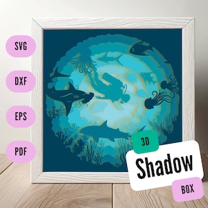 Könnte beinhalten: Ein 3D-Schattenkasten-Kunstwerk, das einen Taucher und verschiedene Meerestiere wie Haie, Quallen und Korallen in einem Blau- und Grünton zeigt. Der Text "3D Shadow Box" ist in der unteren rechten Ecke sichtbar.