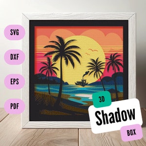 Könnte beinhalten: Ein 3D-Schattenkasten-Kunstwerk, das eine Sonnenuntergangsszene mit Palmen, einem Boot und einem Strand darstellt. Die Box ist weiß gerahmt und trägt das Label "3D Shadow Box".