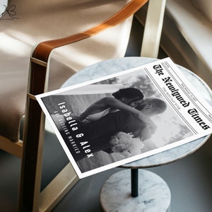 May include: A black and white photo of a couple embracing, printed on a newspaper-style announcement with the headline "The Newlywed Times" and the text "Isabella & Alex are getting married".