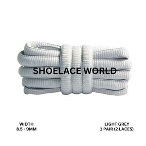Peut inclure: Lacets gris clair, de 8,5 à 9 mm de large, enroulés. Le texte "SHOELACE WORLD" est imprimé sur les lacets. Le texte "LIGHT GREY 1 PAIR (2 LACES)" est également imprimé sur l'image.