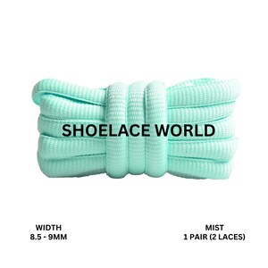 Peut inclure: Un paquet de lacets vert menthe de Shoelace World. Les lacets sont de couleur unie et semblent être faits d'un matériau tissé. La largeur est de 8,5 à 9 mm. Le texte "MIST 1 Pair (2 Laces)" est également visible.