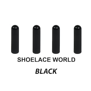May include: Four identical black cylindrical aglets with rounded tops arranged in a horizontal row. Below the aglets, the text SHOELACE WORLD is printed in black capital letters, followed by the word BLACK in an italicized black font.