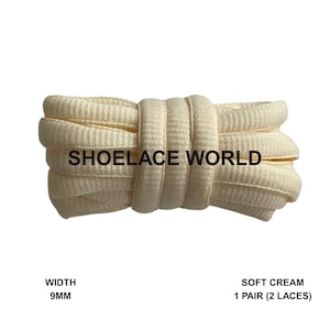 May include: A bundle of soft cream-coloured shoelaces, 9mm wide. The text "SHOELACE WORLD" is printed on the laces. The product is labelled as "SOFT CREAM 1 PAIR (2 LACES)".