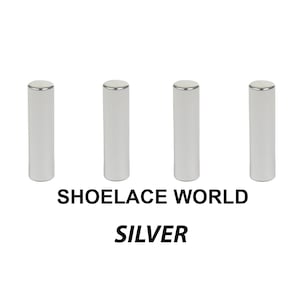 May include: Four silver shoelace aglets with a metallic silver finish and a silver rim. The text "SHOELACE WORLD" and "SILVER" are printed below the aglets.