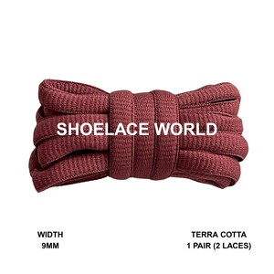 May include: A bundle of terra cotta-colored shoelaces, 9mm wide, from Shoelace World. The laces are neatly coiled and ready for use. The image shows a close-up of the laces, highlighting their texture and color.