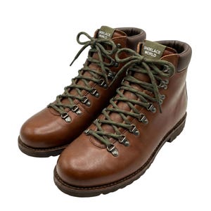 May include: A pair of brown leather hiking boots with olive green laces. The boots have metal eyelets and the text "SHOELACE WORLD" on the tongue. The boots are new and unworn.
