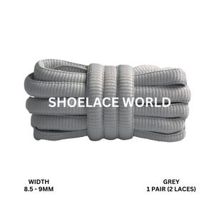 Peut inclure: Un paquet de lacets gris, avec le texte "SHOELACE WORLD" en blanc. Les lacets mesurent 8,5 à 9 mm de large. Le texte "GREY 1 PAIRE (2 LACETS)" est également visible.